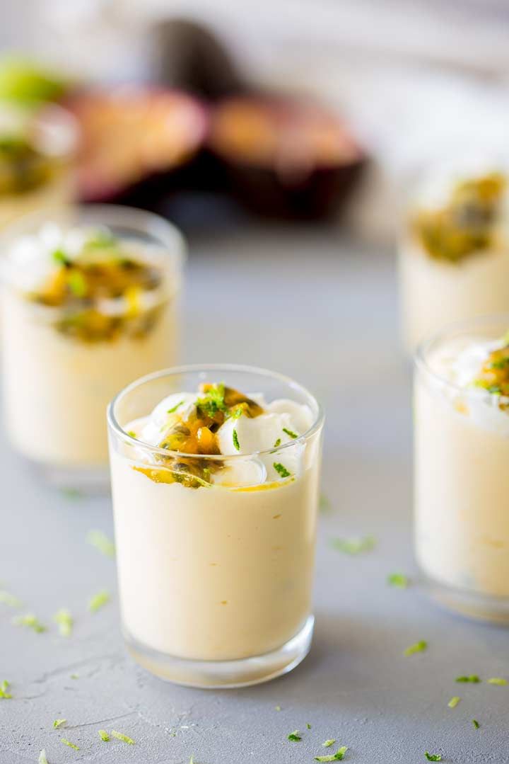 mini passionfruit cream pots with whipped cream and pistachio sauce on top