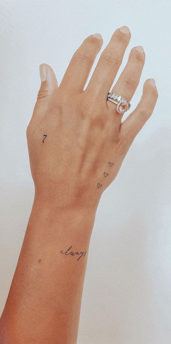 a woman's hand with tattoos on her left wrist and the word love written in cursive writing