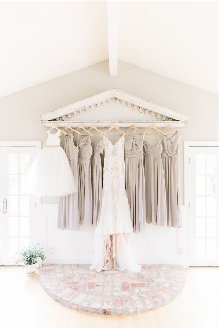 the bride's dress hangs in front of her bridal gowns