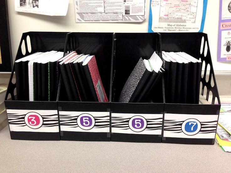 an office cubicle with file folders and dividers on the desk area, decorated in black and white