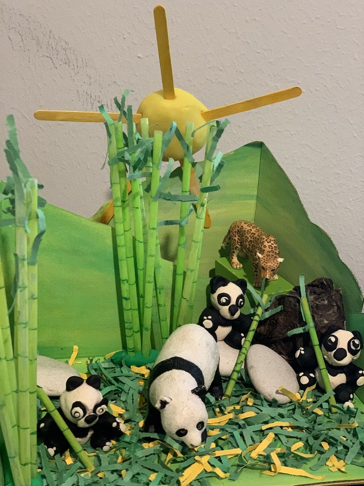 there are many pandas in the grass on this cake, and one is eating bamboo