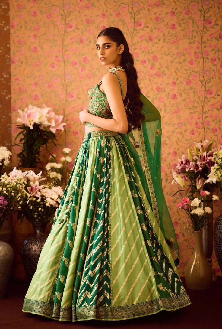 Step into refined elegance with the jasper green hand-embroidered silk brocade blouse, beautifully paired with a multi-panel brocade lehenga. This exquisite ensemble features intricate embroidery that enhances the luxurious fabric, while the lehenga adds depth and flair. An embroidered belt cinches the waist, and the matching dupatta completes the look, making it a perfect choice for festive celebrations and special occasions. Brocade Lehenga, Brocade Blouse, Green Lehenga, Brocade Blouses, Embroidered Belt, Casual Tunics, Green Hand, Silk Brocade, Intricate Embroidery