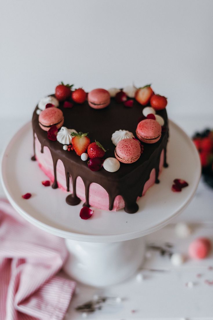 a heart shaped cake with chocolate icing and strawberries