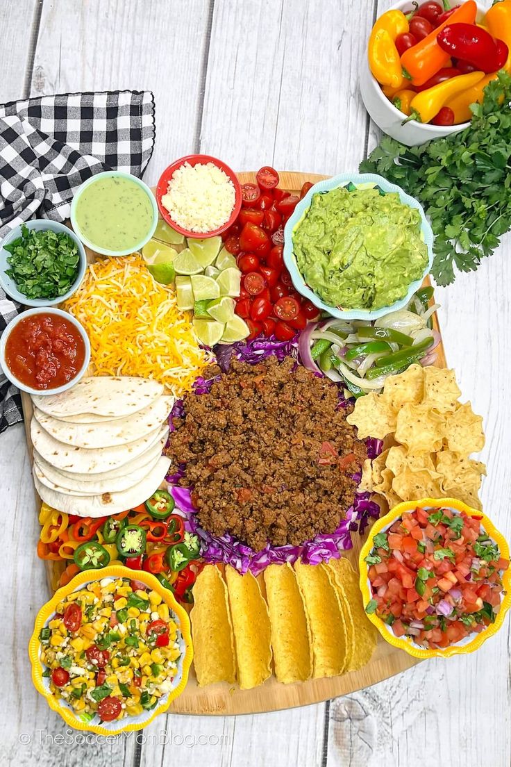 a platter filled with tacos, tortillas and salsa