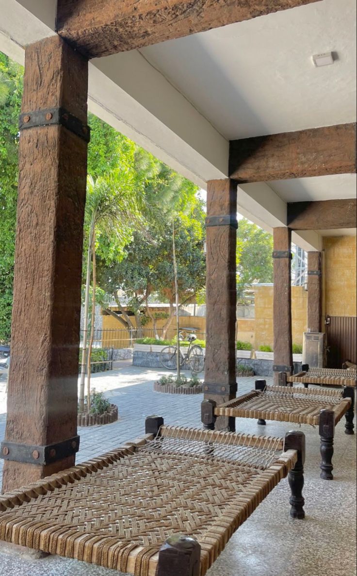 some benches are lined up on the side of an outdoor area with trees in the background