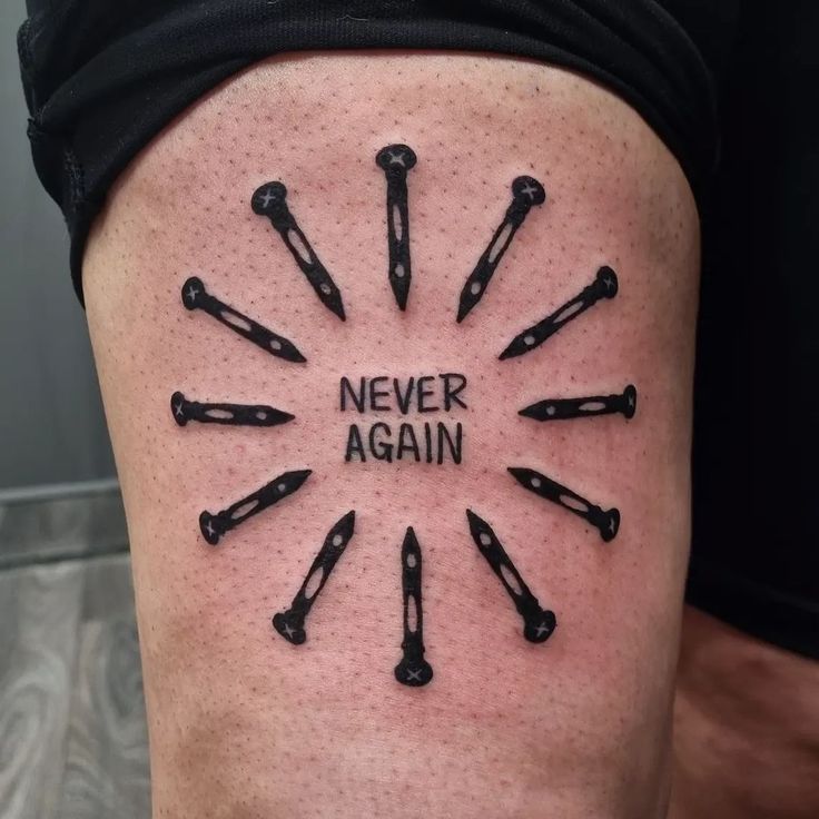 a tattoo with the words never again written on it and lots of black tools arranged in a circle