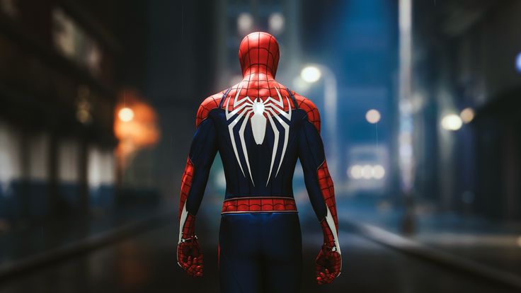 a spider - man standing in the middle of a street at night with his hands on his hips