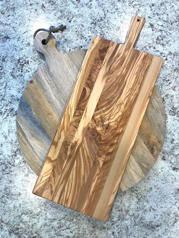 a wooden cutting board sitting on top of a granite counter next to a pair of scissors