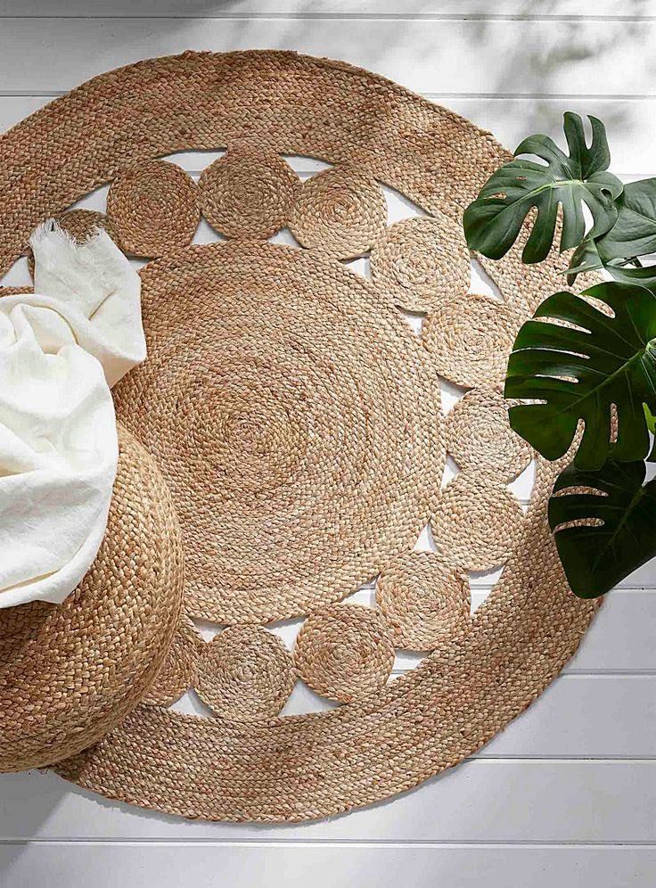 two round placemats and a potted plant on a white wooden table top