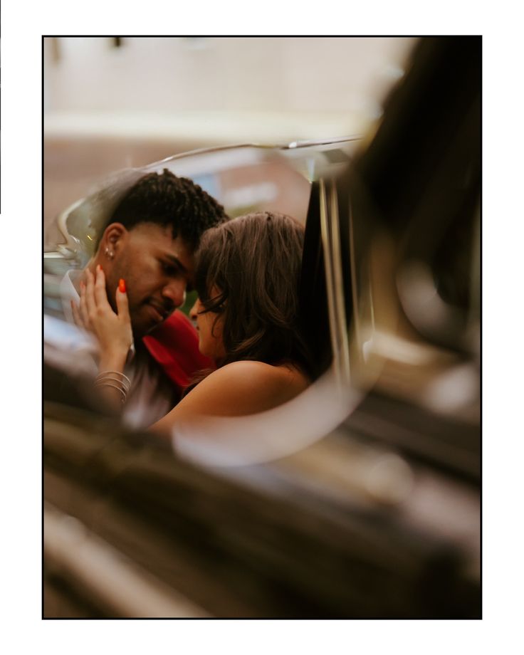 a man and woman are kissing in a car