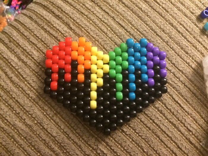 a multicolored beaded heart sitting on top of a table