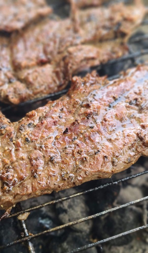 the steak is cooking on the grill with it's meat being grilled and ready to be eaten