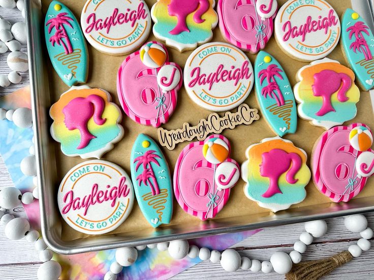 decorated cookies in the shape of elephants and flamingos are on a tray with candy