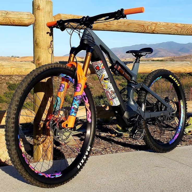 a bicycle parked next to a wooden fence