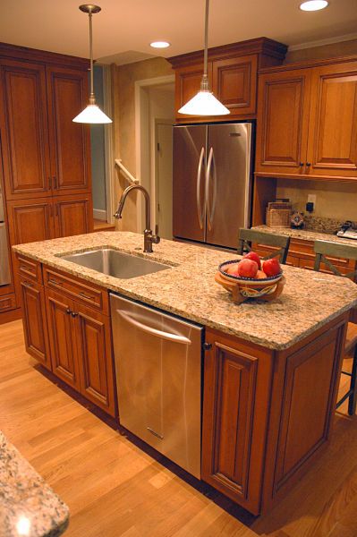 a kitchen with wooden cabinets and granite counter tops, stainless steel refrigerator and dishwasher