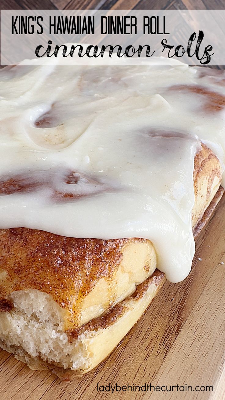 a cinnamon roll with icing sitting on top of a wooden cutting board