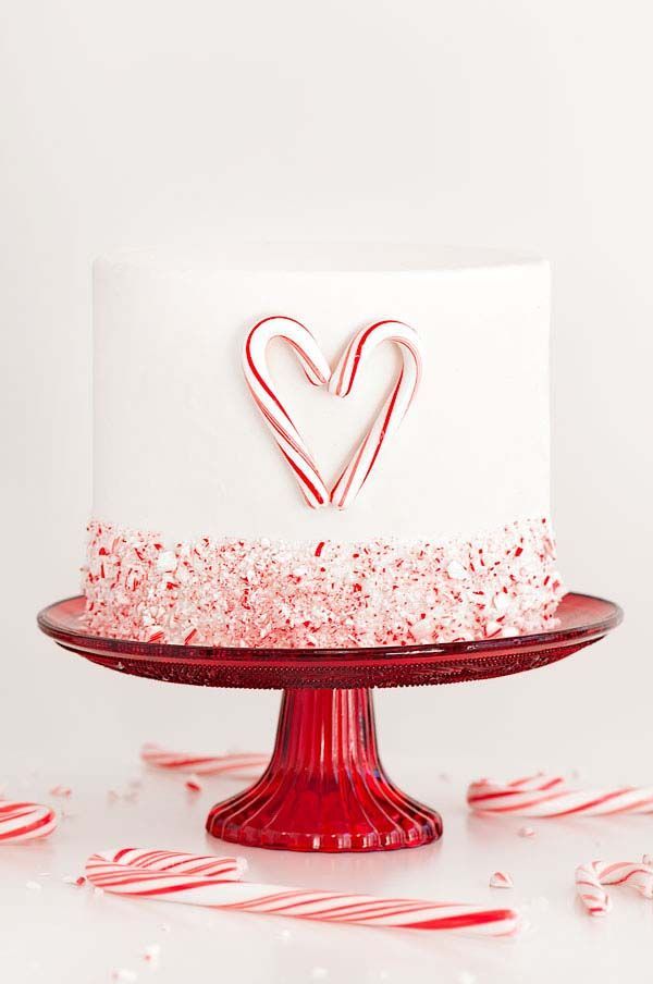 a white and red cake with candy canes around it