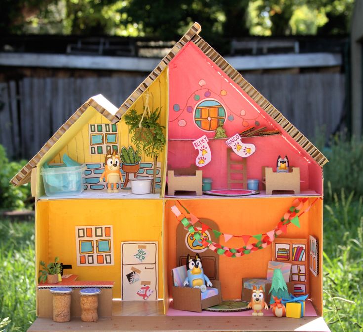 a doll house with lots of furniture and decorations on top of it in the grass