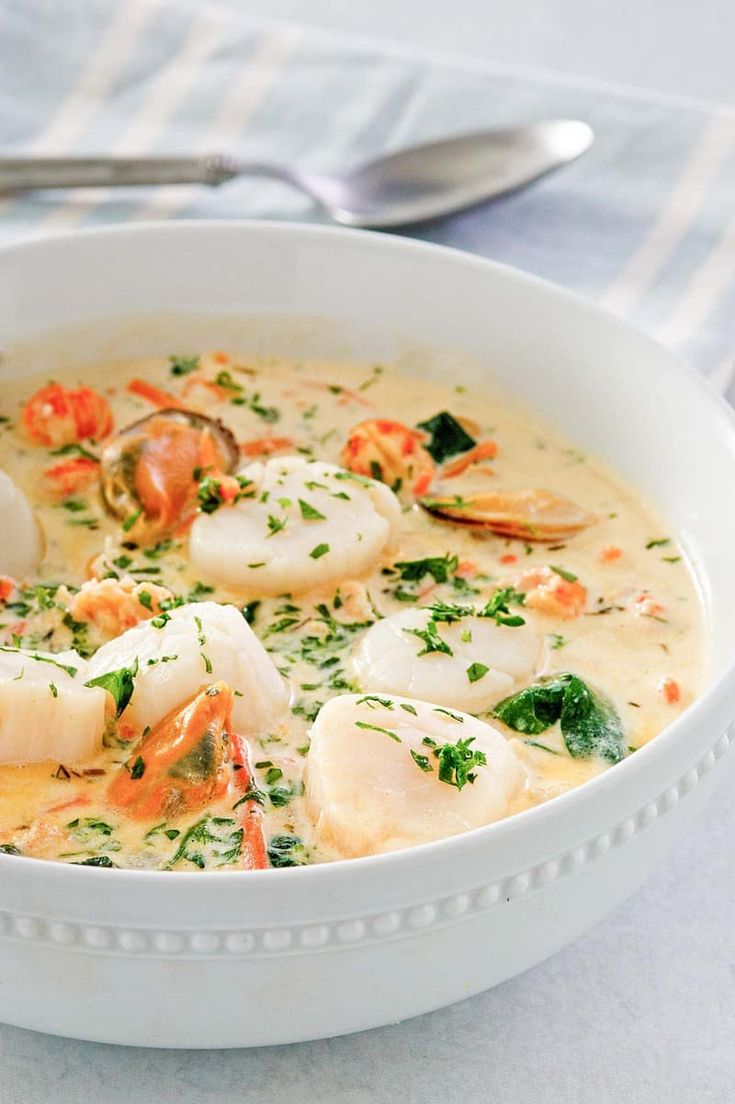 a white bowl filled with seafood and broth