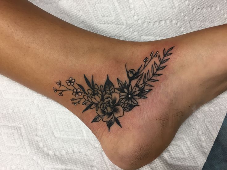 a close up of a person's foot with a flower tattoo on it,