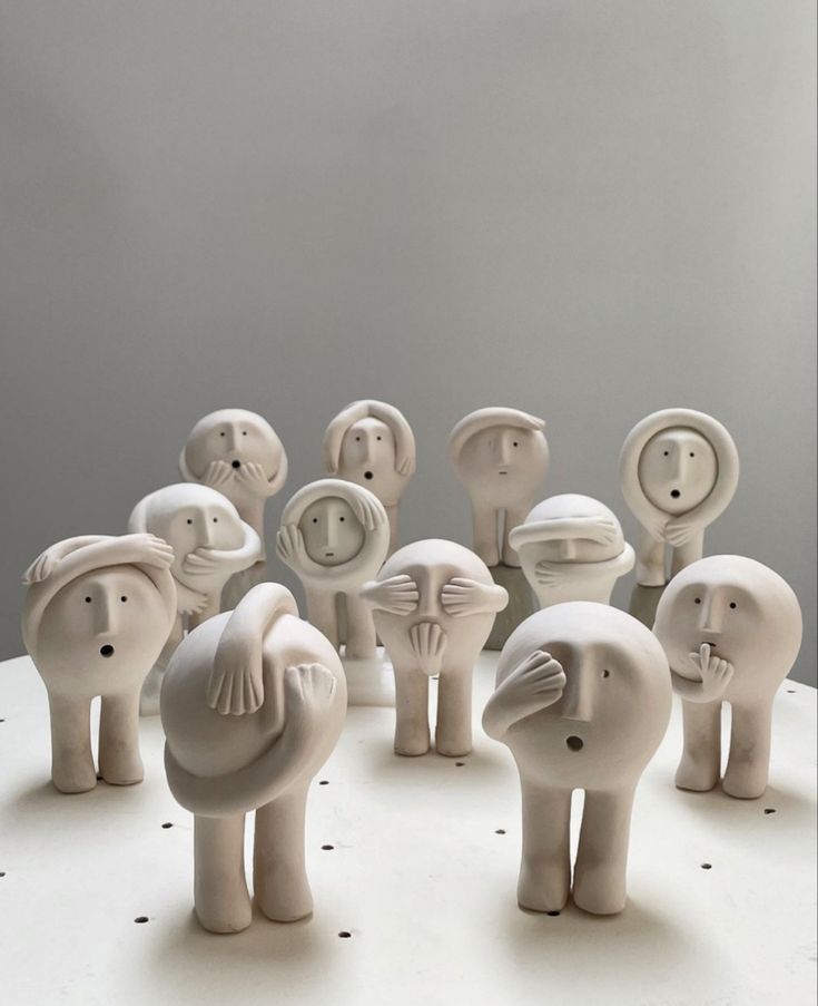 a group of ceramic elephants standing on top of a white table