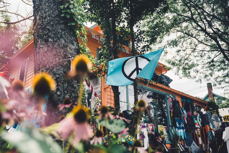 a blue peace sign hanging from the side of a tree in front of a building