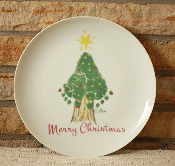 a white plate with a christmas tree on the front and merry christmas written on it