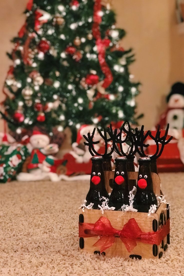 there are three reindeers sitting in a sleigh next to a christmas tree