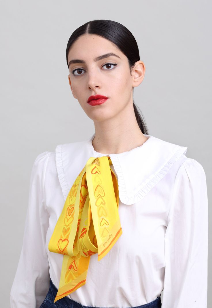 This skinny printed silk scarf is all you need in order to add elegance and color to your wardrobe. Crafted in Italy from beautiful twill silk according to an original design by Dikla Levsky, this narrow scarf is a super versatile. Whether worn around your neck, on your wrist or looped around your waist, its long and narrow shape offers effortless style. This piece has two complementary sides, both in beautiful yellow and orange shades and sweet printed hearts. Colors: shades of yellow and orang Gold Silk Scarf For Spring, Elegant Gold Scarves For Spring, Trendy White Silk Scarf For Formal Occasions, Formal Scarf Neckwear, Elegant Yellow Silk Scarf For Spring, Classic Silk Scarf For Spring Gift, Yellow Silk Scarf For Spring Gift, Yellow Silk Scarf For Spring, Elegant Yellow Silk Scarf