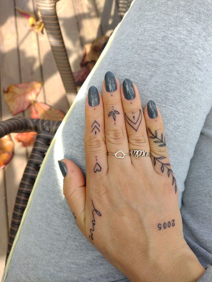 a woman's hand with tattoos on it