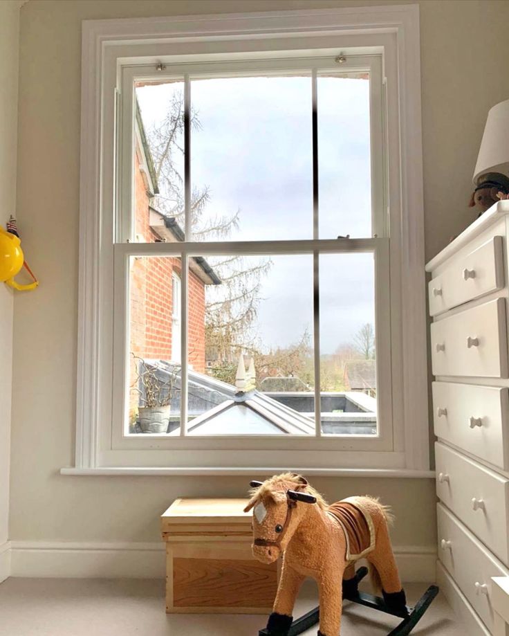 a toy horse sitting in front of a window