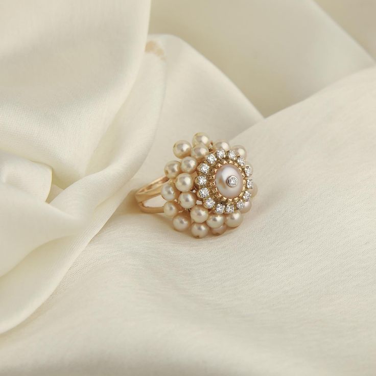 Life is movement! Building on this truth we worked on the concept of movement. This elegant cocktail ring handcrafted in gold holds a diamond pierced pearl dearly in the centre lined with prong-set diamonds, finished with an arrangement of pearls that move with you. Gold(14K) : 7.40g Brilliant cut Diamonds : (VS clarit Moi Jewellery, Pearl Ring Designs, Pearl Ring Design, Pearl Ring Simple, Nepali Jewelry, Gold Stacking Rings Wedding, Bridal Jewelry Vintage, Pearl Rings, Pearl Jewelry Wedding