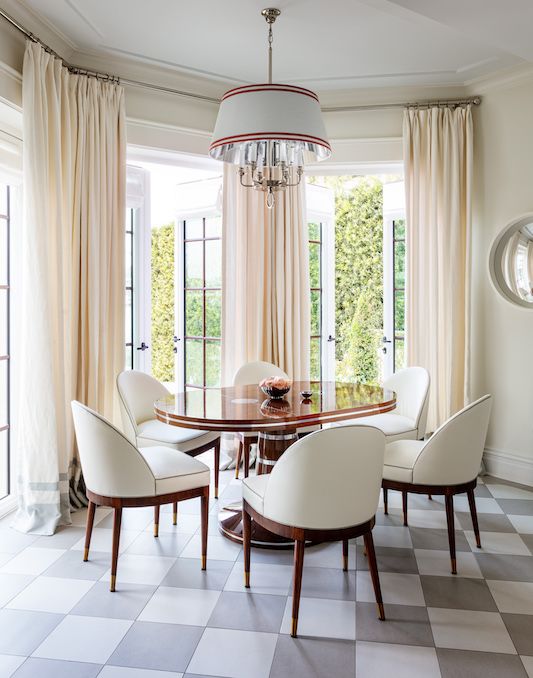 a dining room table with white chairs and a chandelier hanging from the ceiling