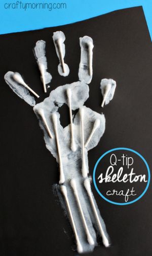 an art project for kids to make skeleton handprints with white paint on black paper