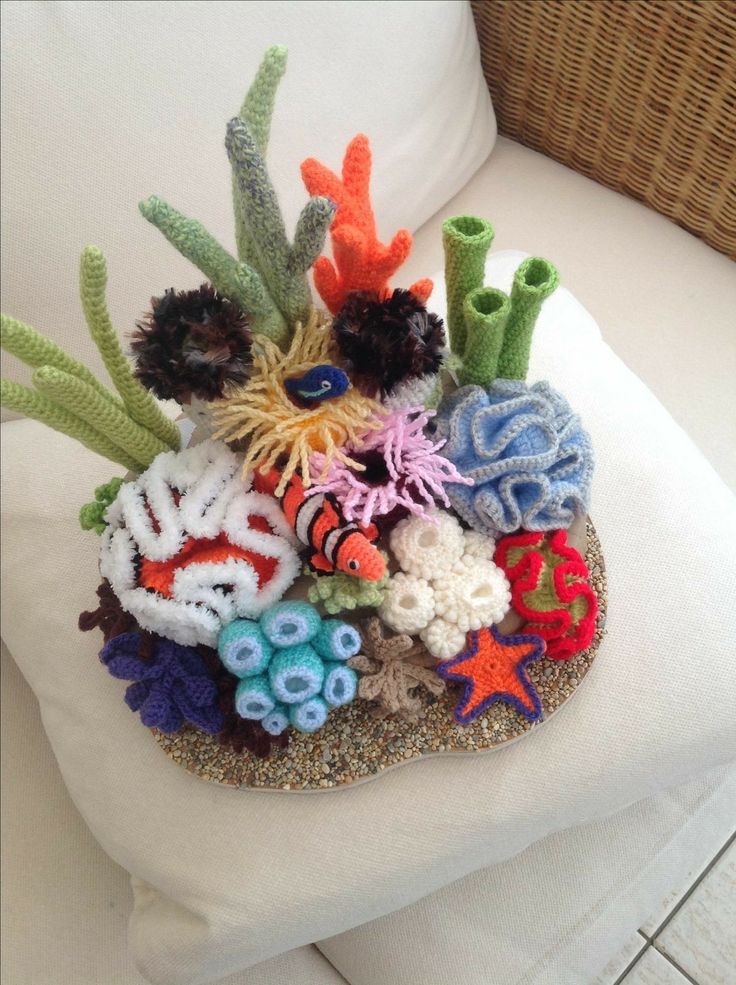 an arrangement of sea life is displayed on a white pillow in front of a wicker basket