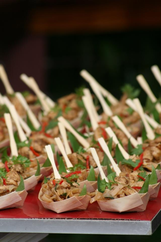 many appetizers are lined up on a red tray with toothpicks sticking out of them