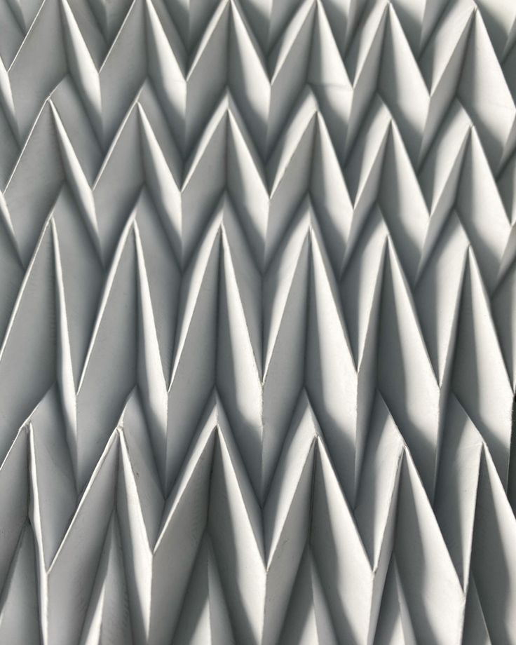 a close up view of an abstract pattern made out of white plastic cones and triangles