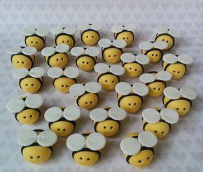 a bunch of yellow and white bees with faces on them, sitting next to each other