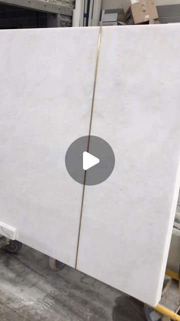 a large white marble slab being worked on in a factory with an arrow pointing to the center