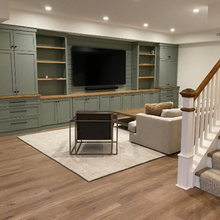 a living room filled with furniture and a flat screen tv mounted on a wall above a fireplace