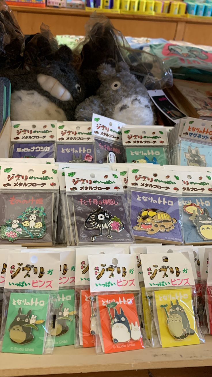 a picture of a variety of colorful studio ghibli pins lined up in a row of 3 and 2 little my neighbor totoro plushies on the top. Super cute pins I founds in a small anime shop in LA. Studio Ghibli Merch Aesthetic, Studio Ghibli Gifts, Studio Ghibli Merch, Studio Ghibli Store, Ghibli Toys, Studio Ghibli Toys, Studio Ghibli Plush, Ghibli Plush, Case Studio