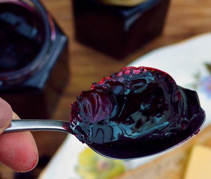 a person holding a spoon with jam on it