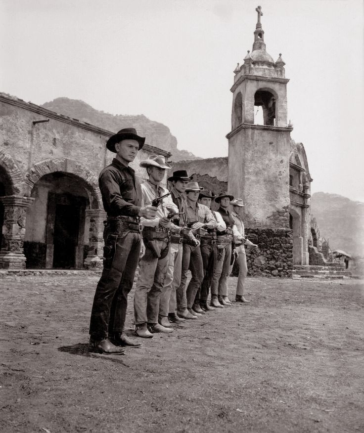 a group of men standing next to each other in front of a church