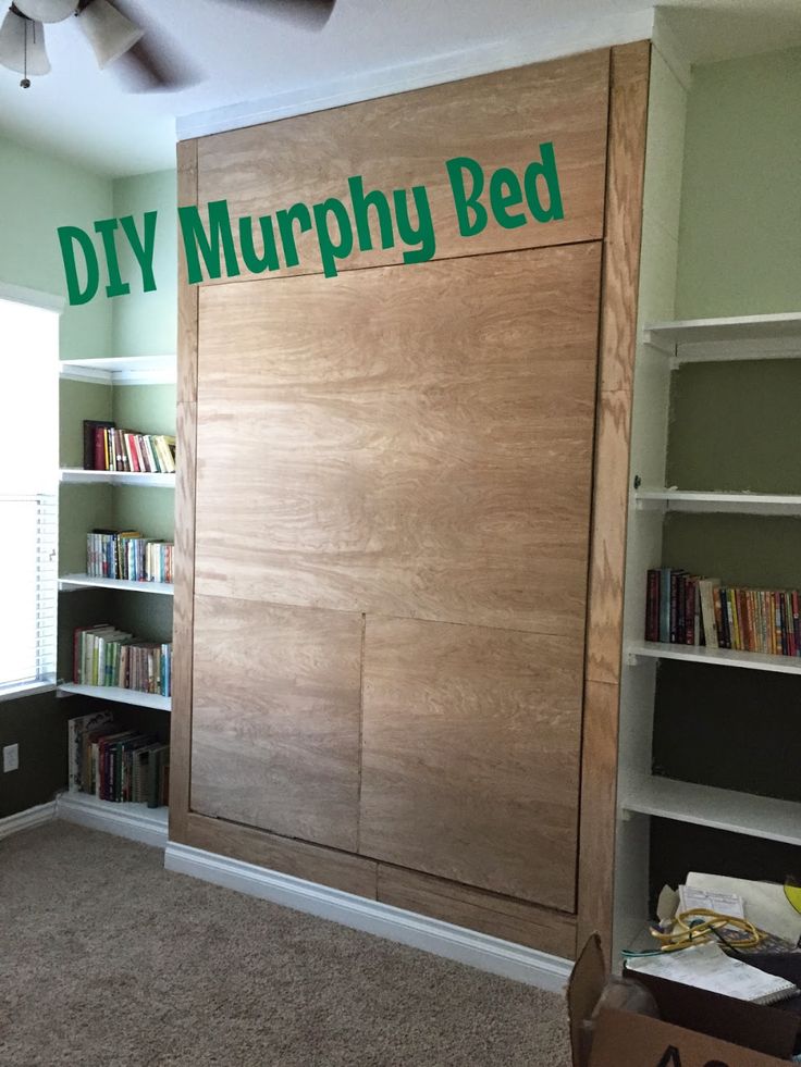 there is a room with bookshelves and shelves on the wall that says diy murphy bed