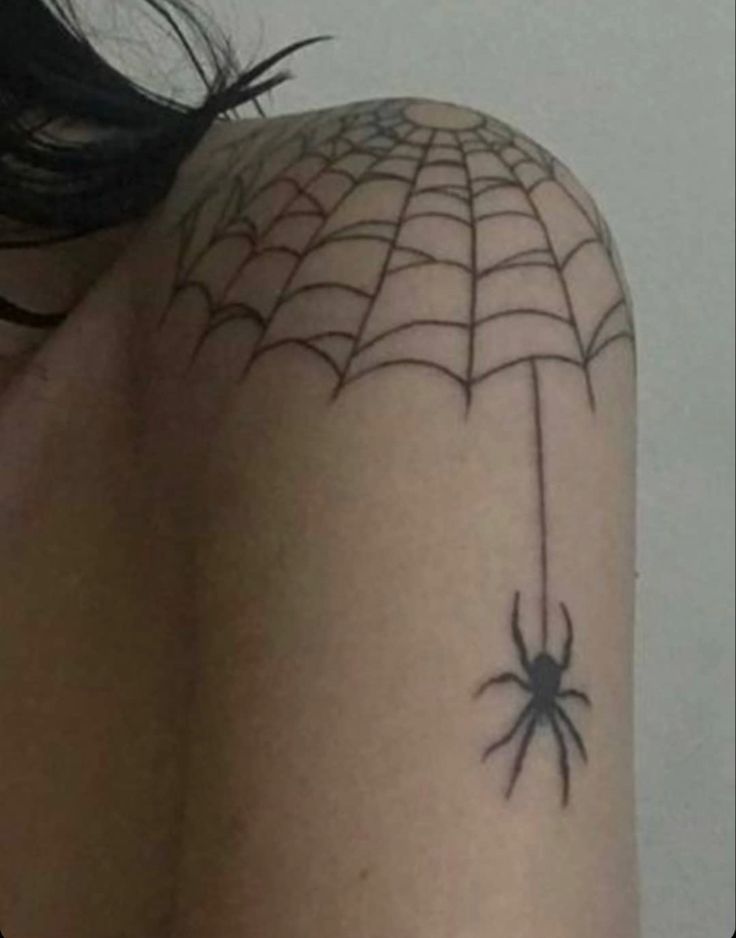 a woman with a spider web tattoo on her shoulder