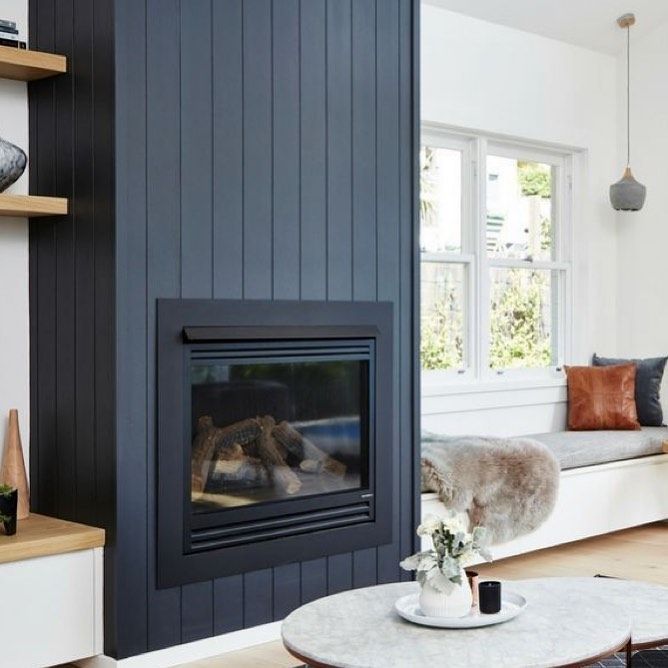 a living room filled with furniture and a fire place in the middle of the room