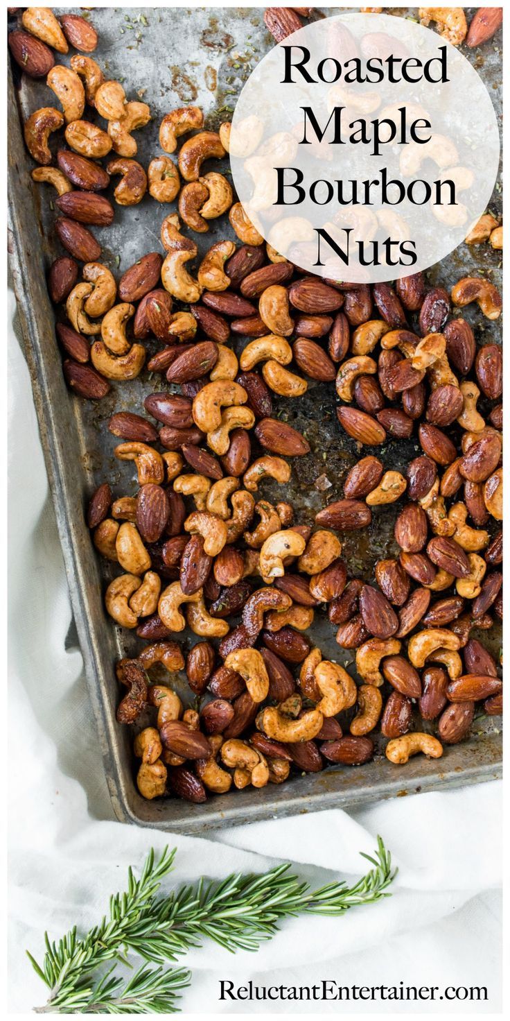 roasted maple bourbon nuts in a baking pan with rosemary sprigs on the side