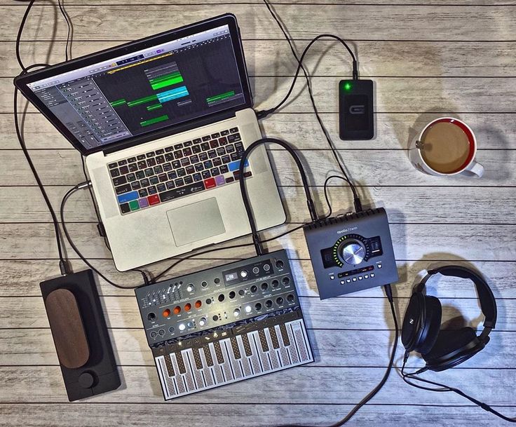 a laptop computer sitting on top of a wooden table next to headphones and other electronics