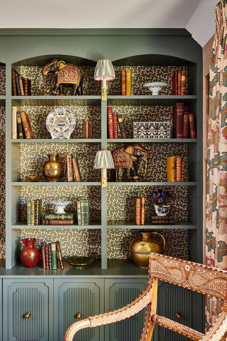 a chair sitting in front of a book shelf filled with books