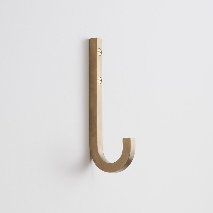 the letter j is made out of wood and has a metal hook on it's side